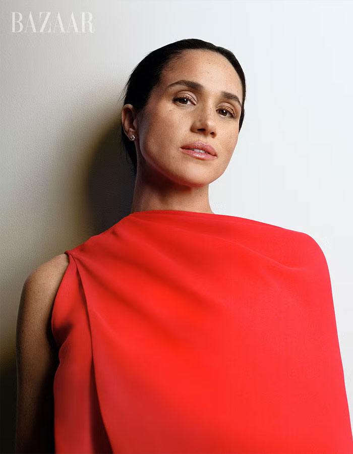 Meghan Markle posing in a striking red outfit for her Harper’s Bazaar moment capturing attention online.