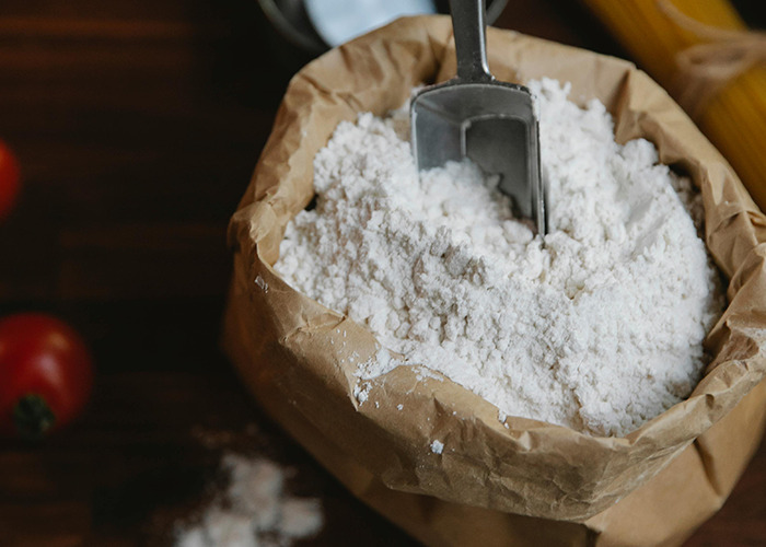 Brown paper bag filled with flour and a metal scoop, illustrating a horrible gift received by 91 people.