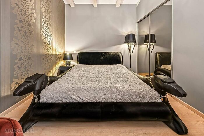 Black animal-shaped bed in a modern bedroom with decorative wall art and mirrored closet in wild real estate listing.