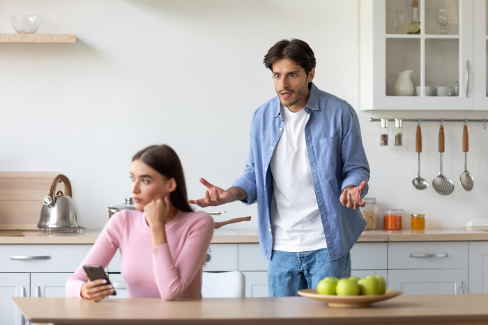 Young couple in kitchen having a serious discussion, illustrating stories of folks realizing compulsory things in life are optional.
