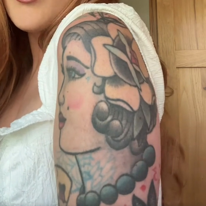 Tattoo artist showing regret with detailed traditional tattoo on upper arm featuring a woman's profile and beads. Tattoo artist showing regret with detailed traditional tattoo on upper arm featuring a woman's profile and beads.