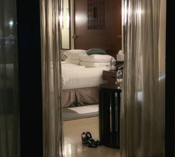 Hotel room interior with unmade bed, bedside table, and sandals on floor, related to provocative influencer body found story. Hotel room interior with unmade bed, bedside table, and sandals on floor, related to provocative influencer body found story.