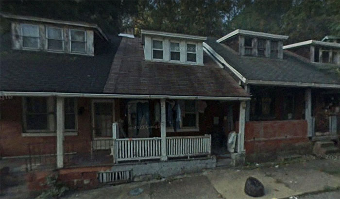 Abandoned house with boarded windows and a dark porch, evoking creepy and terrifying urban explorer moments.