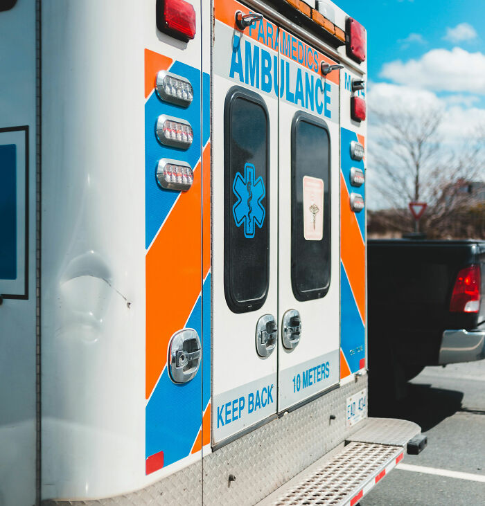Ambulance parked outside hospital, highlighting emergency medical services in hospitals and clinics.