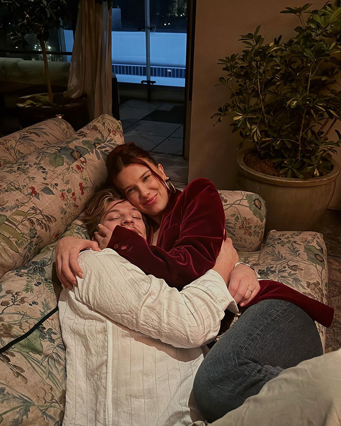 Two people hugging on a floral couch at night, related to Millie Bobby Brown name change news and fan reactions. Two people hugging on a floral couch at night, related to Millie Bobby Brown name change news and fan reactions.