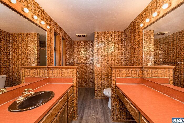 Vintage bathroom with bold wallpaper and orange countertops in a unique Zillow home listing to see and believe