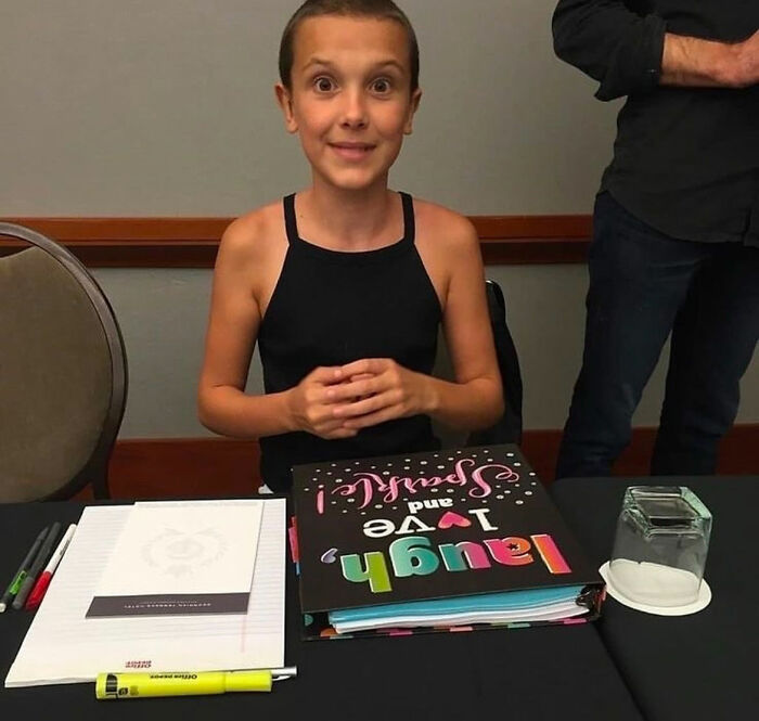 Millie Bobby Brown sitting at a table with a colorful notebook, highlighting bullying issues faced by the Stranger Things star. Millie Bobby Brown sitting at a table with a colorful notebook, highlighting bullying issues faced by the Stranger Things star.