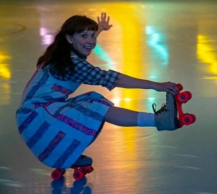 Actress from Stranger Things roller skating indoors, highlighting bullying issues involving Millie Bobby Brown. Actress from Stranger Things roller skating indoors, highlighting bullying issues involving Millie Bobby Brown.