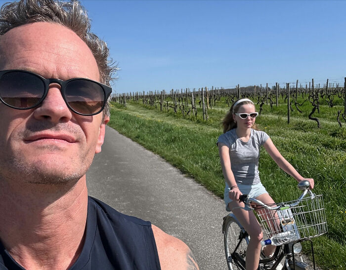 Neil Patrick Harris' daughter Harper, 15, riding a bike outdoors wearing sunglasses and a grey t-shirt. Neil Patrick Harris' daughter Harper, 15, riding a bike outdoors wearing sunglasses and a grey t-shirt.