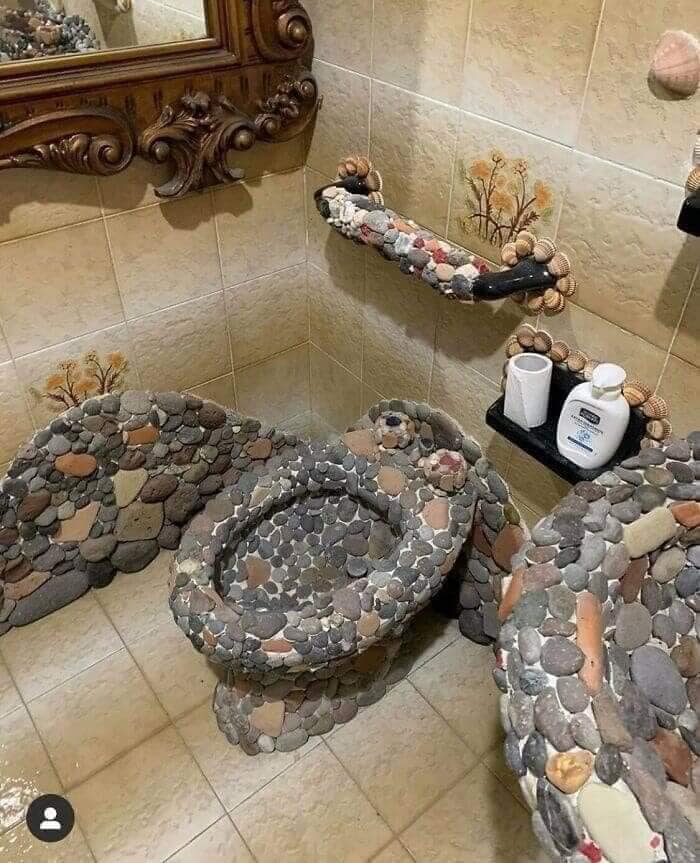 Bathroom interior with a handmade stone-covered toilet and sink showcasing unique Zillow homes design features.