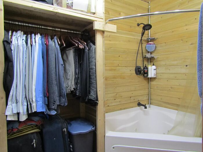 Closet and bathroom with wooden walls in a unique Zillow home, showcasing creative space use and design features.