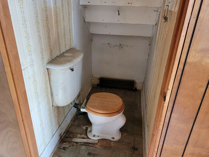 Small outdated bathroom with wooden toilet seat in an old house featured in Zillow homes you have to see to believe.