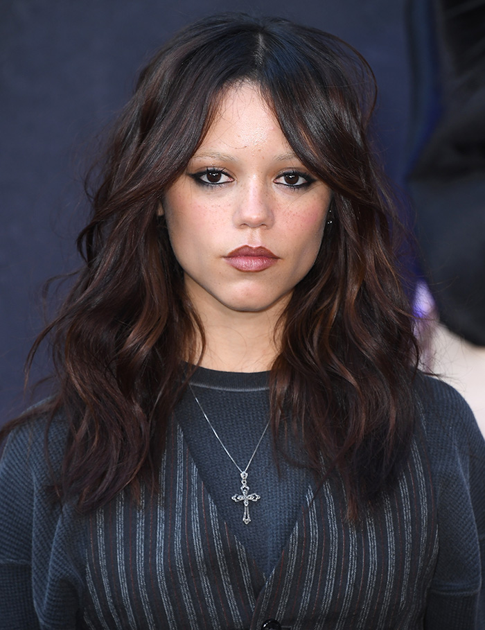 Young female celebrity with dark wavy hair and bold makeup wearing a cross necklace, representing beauty with golden ratio standards. Young female celebrity with dark wavy hair and bold makeup wearing a cross necklace, representing beauty with golden ratio standards.