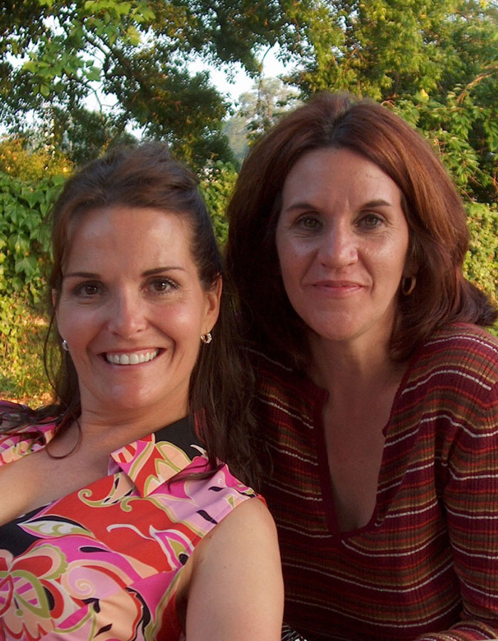 Two women smiling outdoors with greenery in the background, related to missing woman’s body discovered in garage news.