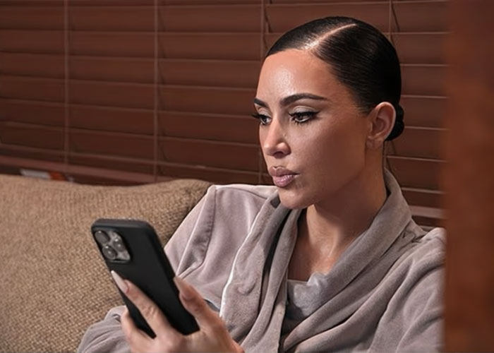 Kim Kardashian focused on her phone, reflecting on excuses for failing the bar exam in a casual indoor setting. Kim Kardashian focused on her phone, reflecting on excuses for failing the bar exam in a casual indoor setting.