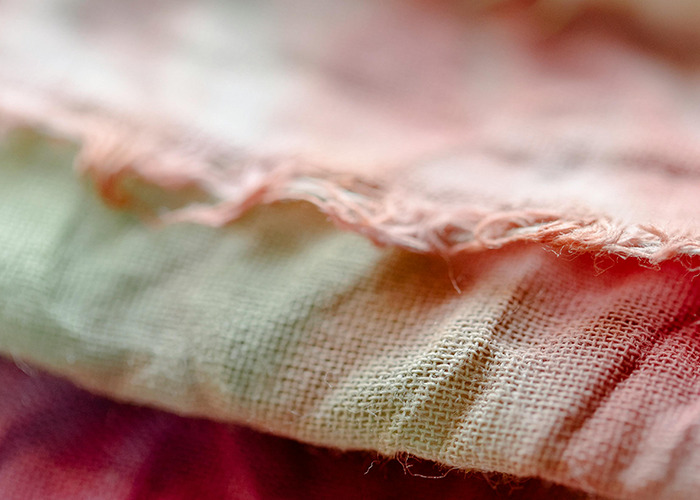 Close-up of rough fabric texture showing frayed edges, illustrating the absolute horrible gifts some people have received.
