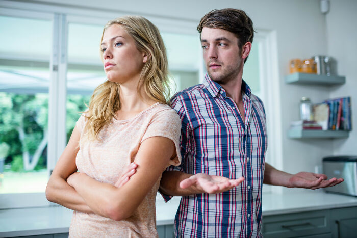 Young couple in kitchen having a disagreement, representing stories from people who messed up once and learned their lesson