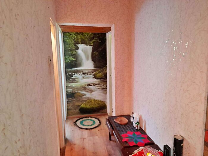 Hallway with a waterfall wall mural at the end, showing a wild real estate listing with unique property decor.
