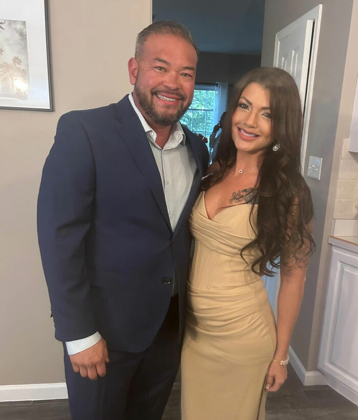 Jon Gosselin in a blue suit standing next to woman in beige dress, both smiling indoors after recent remarriage. Jon Gosselin in a blue suit standing next to woman in beige dress, both smiling indoors after recent remarriage.