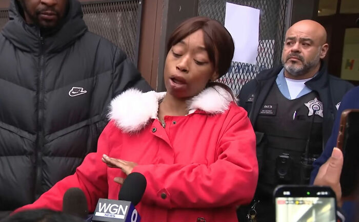 Woman in red coat speaking to media after pregnant woman is attacked by young school kids, with police present nearby. Woman in red coat speaking to media after pregnant woman is attacked by young school kids, with police present nearby.