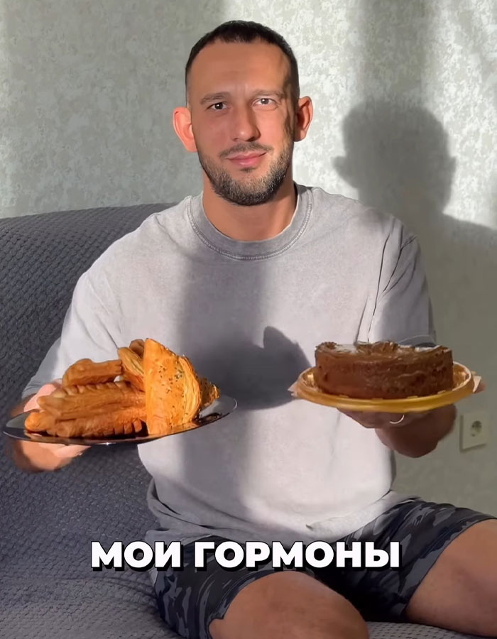 Fitness coach holding plates of pastries and cake during a binge-eating challenge involving mayo, seated indoors Fitness coach holding plates of pastries and cake during a binge-eating challenge involving mayo, seated indoors