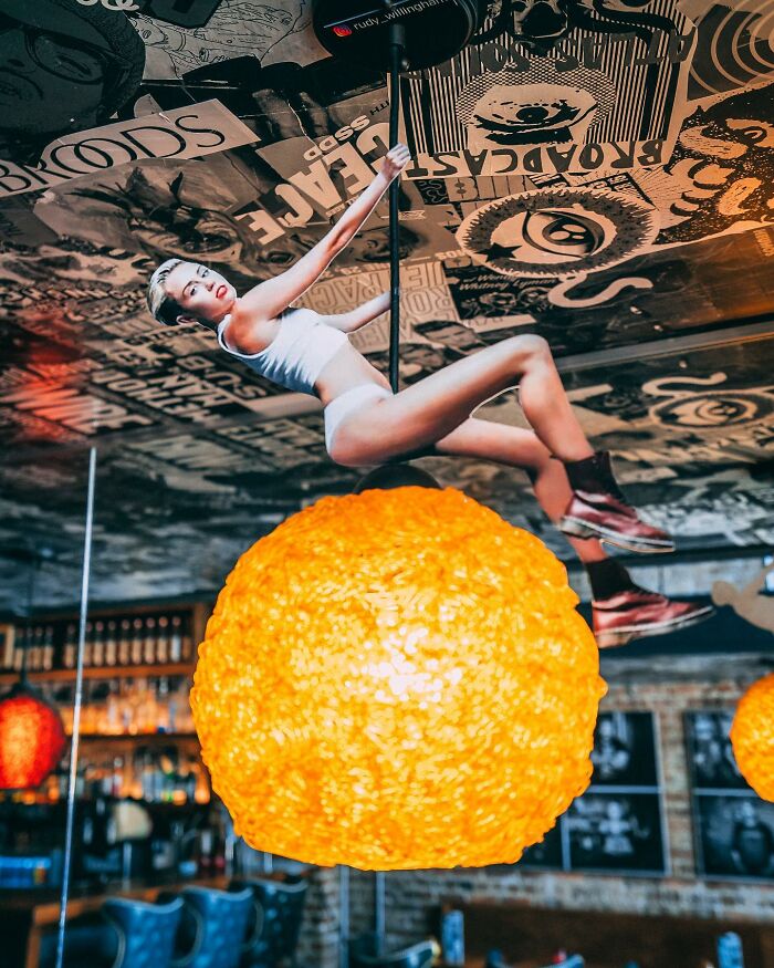 Woman pole dancing on ceiling lamp, creative paper cutouts by Rudy Willingham interacting with real life scene