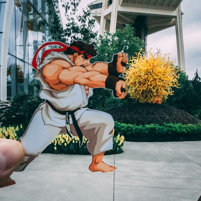 Paper cutouts by Rudy Willingham showing a cartoon figure interacting with real-life outdoor sculpture and environment.