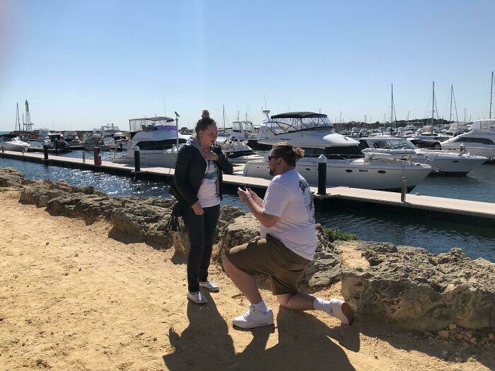 Man kneeling and proposing by marina, a touching moment showing faith in humanity restored through kindness between strangers.