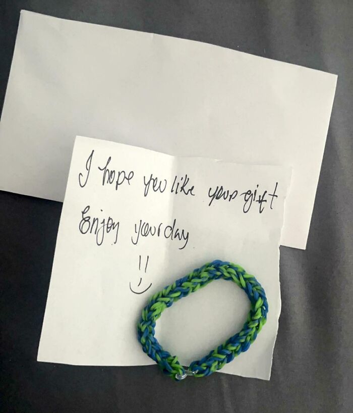Handwritten note with a smiley face and a colorful bracelet showing kindness and faith in humanity restored.