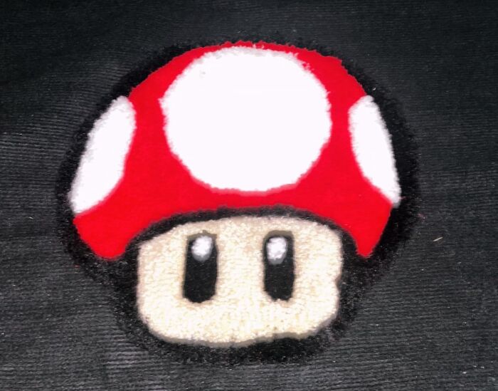 Felt mushroom craft on black fabric, illustrating a creative hobby to keep hands busy during hibernation season.