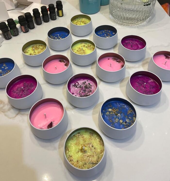 Colorful homemade candles arranged on a table with essential oils, a creative hobby to keep your hands busy during hibernation season