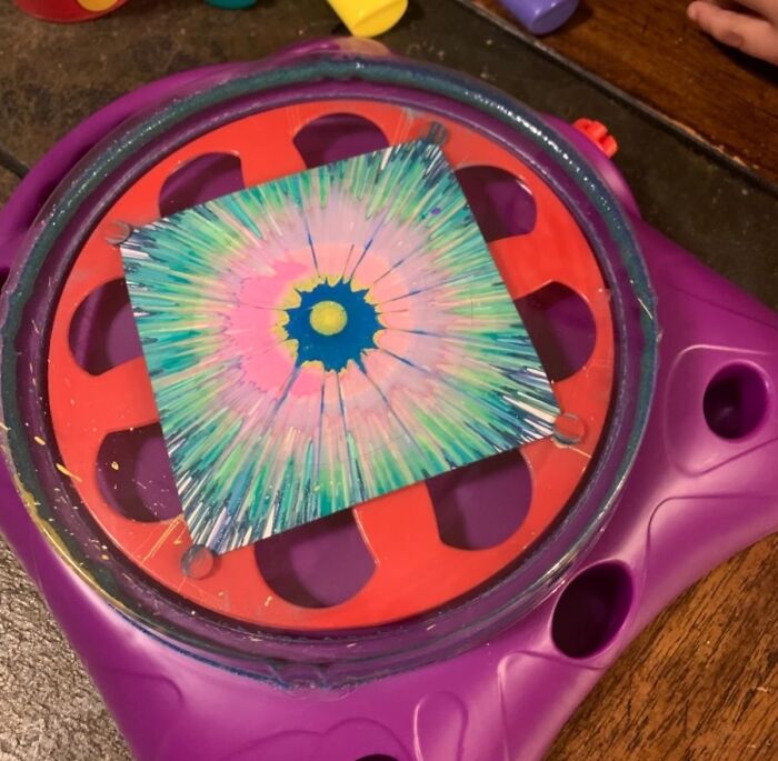 Colorful spin art being created on a square canvas using a spinning hobby tool, showcasing hobbies to keep hands busy.
