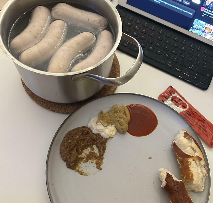 Boiling sausages in a pot with a plate of sauces and pretzel pieces, illustrating iconic girl dinner combos.