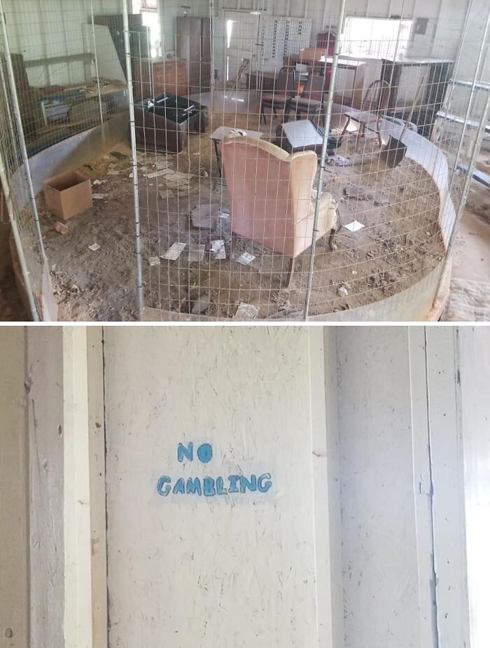 Abandoned Zillow home with a fenced dirt area and worn furniture, featuring a wall sign that says no gambling.