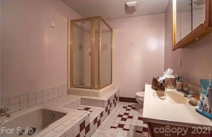 Tile bathroom with shower enclosure and bathtub in Zillow home listed for sale with unique features.