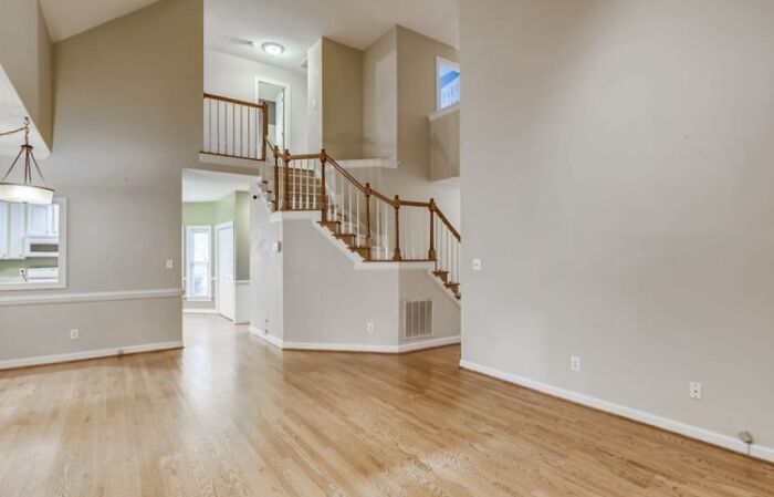Spacious empty home interior with hardwood floors and staircase, one of the Zillow homes you have to see to believe