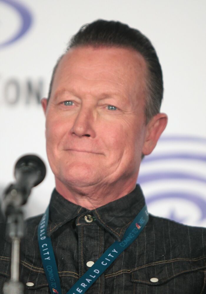 Robert Patrick speaking at an event, wearing a dark shirt and lanyard, highlighting key moments in his career.