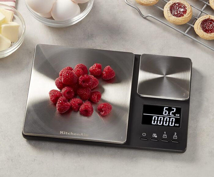 Digital kitchen scale with raspberries on the weighing platform, showcasing new kitchen finds for precise cooking.