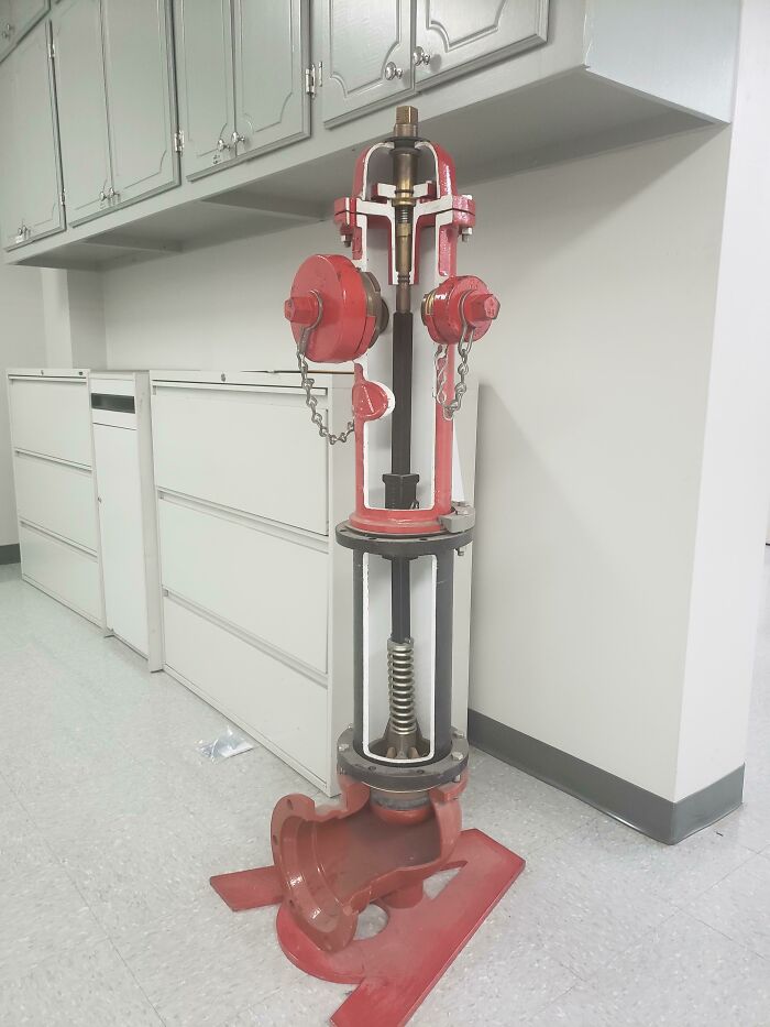 Cutaway view of a red fire hydrant showing the insides and mechanical components in detail.