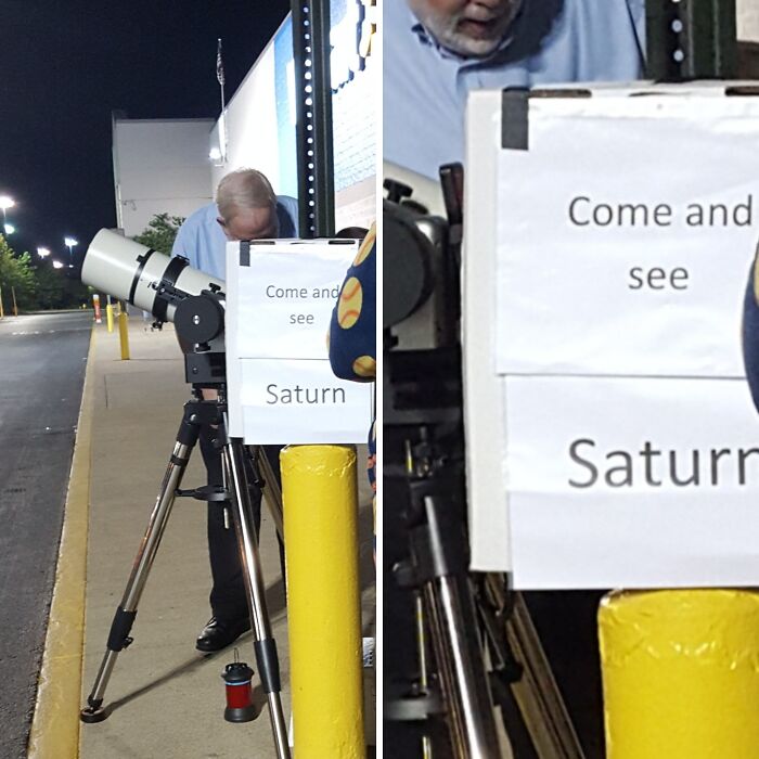 Man using a telescope on a sidewalk at night with a sign inviting strangers to see Saturn in the sky.