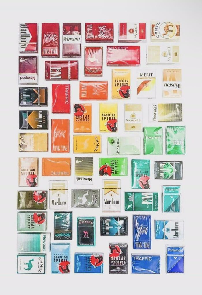 Various cigarette packs neatly arranged by color in a knolled layout, showcasing order and organization satisfaction.