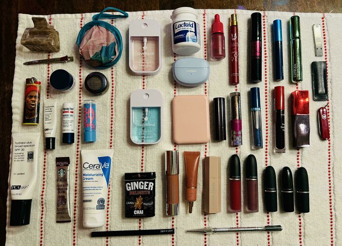 Neatly arranged beauty and personal care products on a towel, showcasing order and organization for satisfying knolled display.