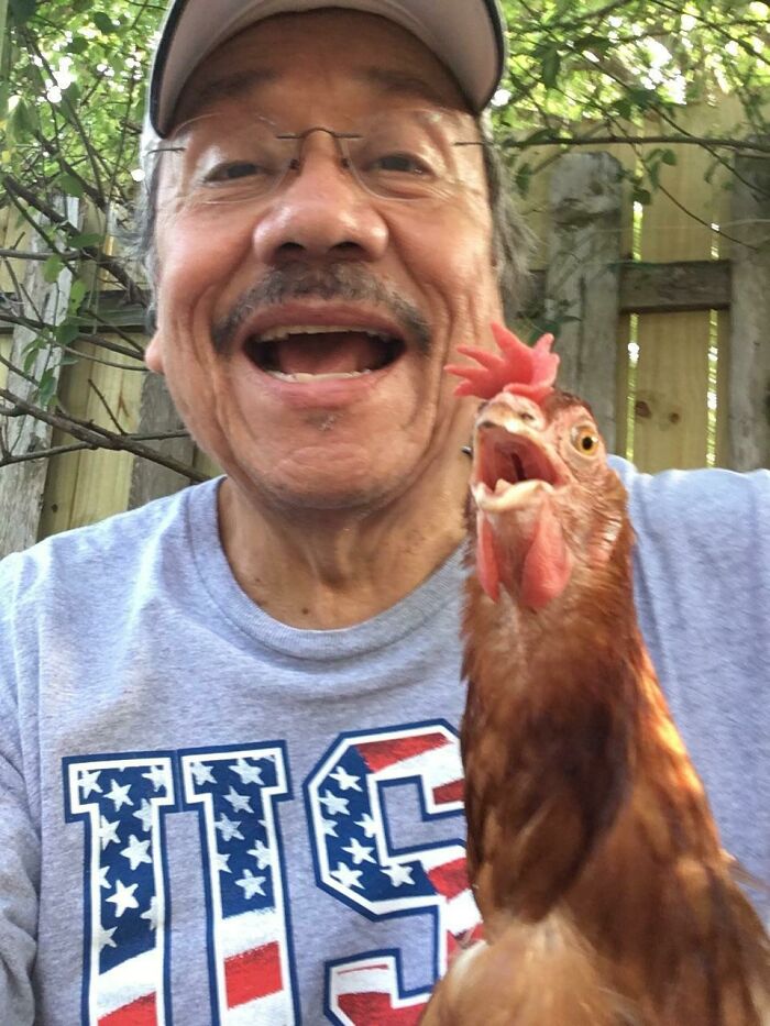 Man and chicken posing outdoors for a fun selfie showcasing animals who can take a better selfie than you.