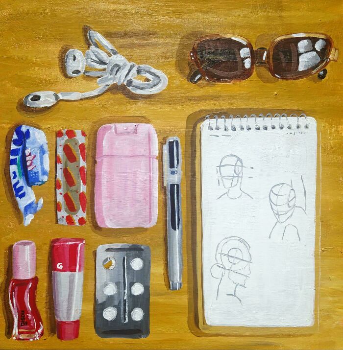 Neatly arranged everyday items including sunglasses, earphones, notebooks, and personal care products illustrating knolled order.