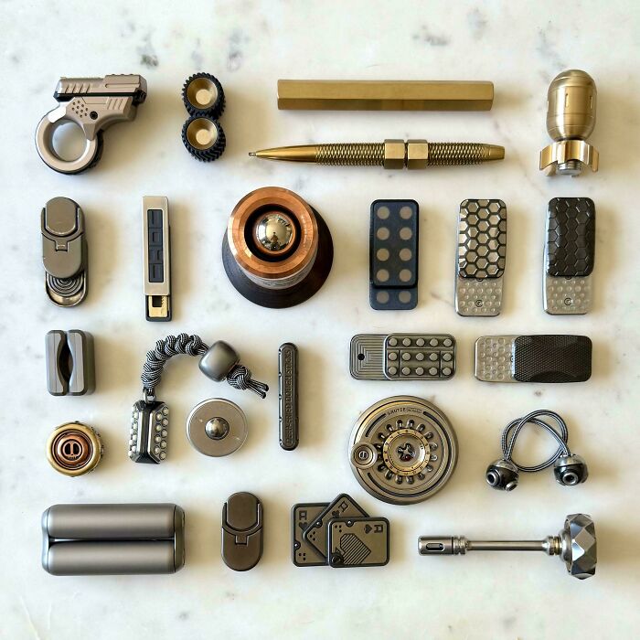 Various knolled mechanical and metallic objects arranged neatly on a white surface, showcasing order and organization.