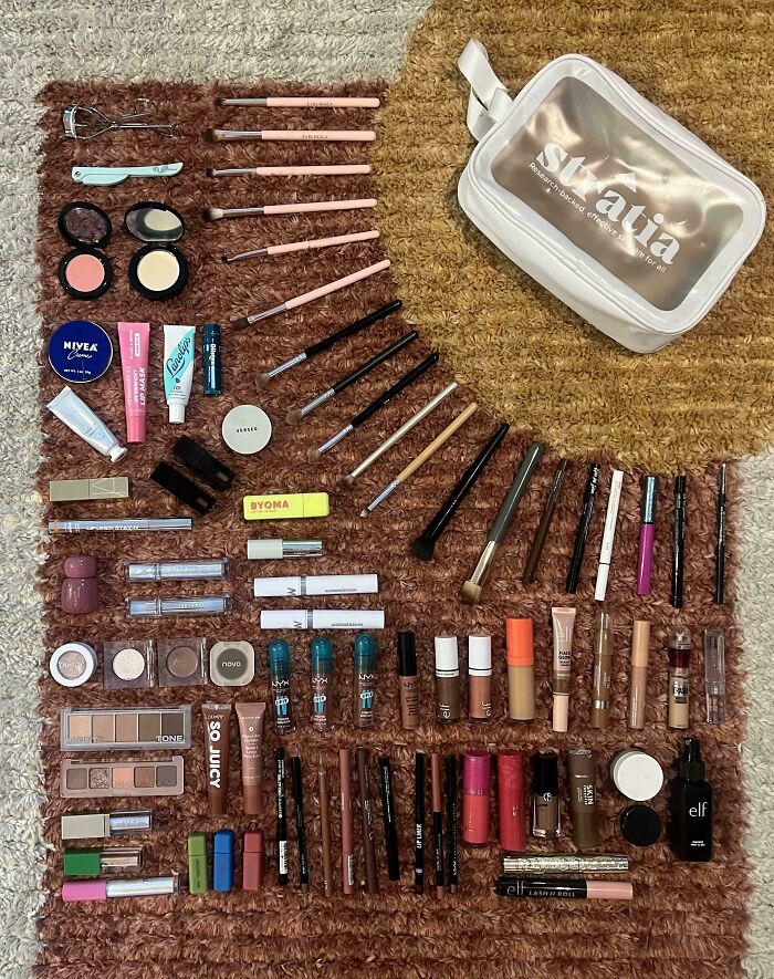 Neatly arranged makeup and skincare products displayed on a textured rug for satisfying all things knolled organization.