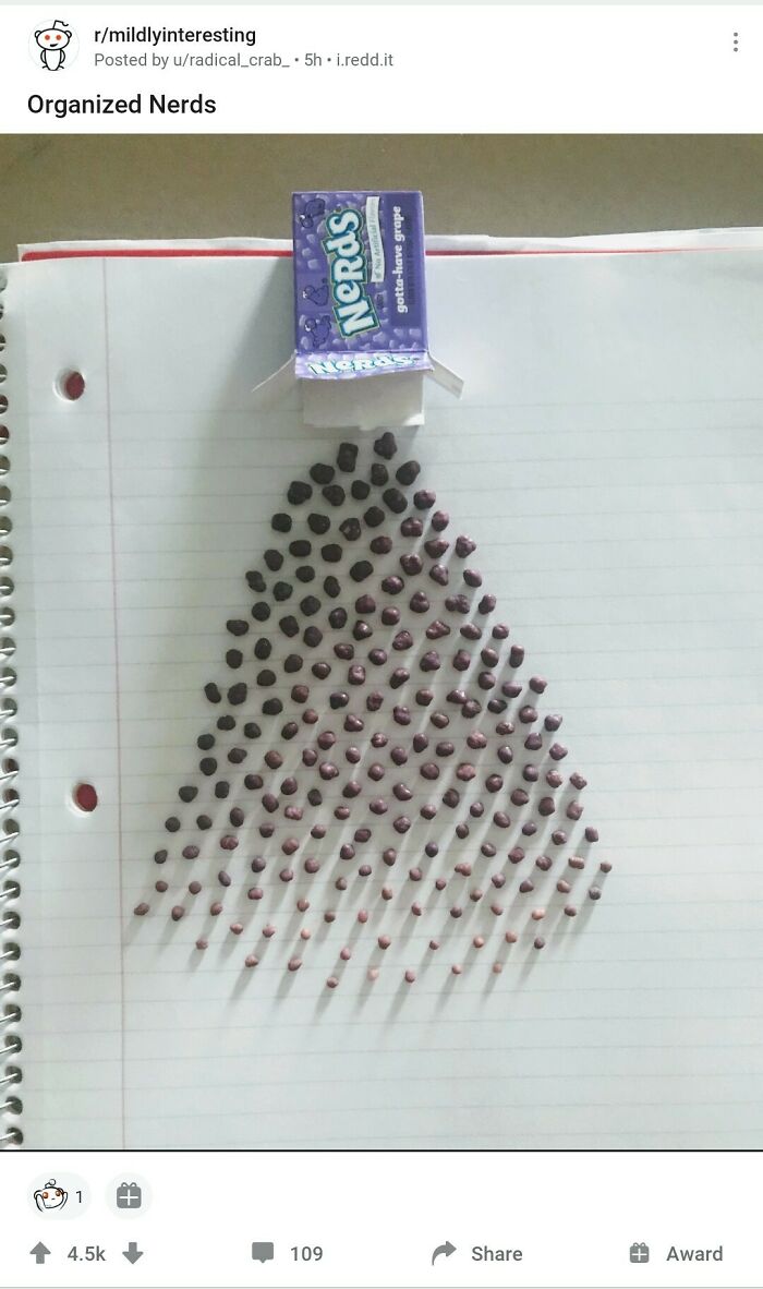 Purple Nerds candies neatly arranged in a triangular pattern on lined paper, showcasing satisfying order and organization.