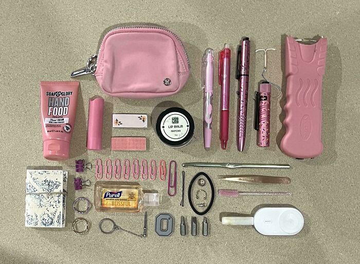 Organized pink everyday items including pens, clips, lip balm, and small pouch arranged neatly for visual order and satisfaction.