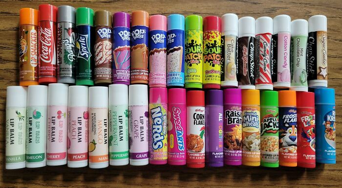 Assorted colorful lip balms neatly arranged in rows, showcasing organized and satisfying order visuals.