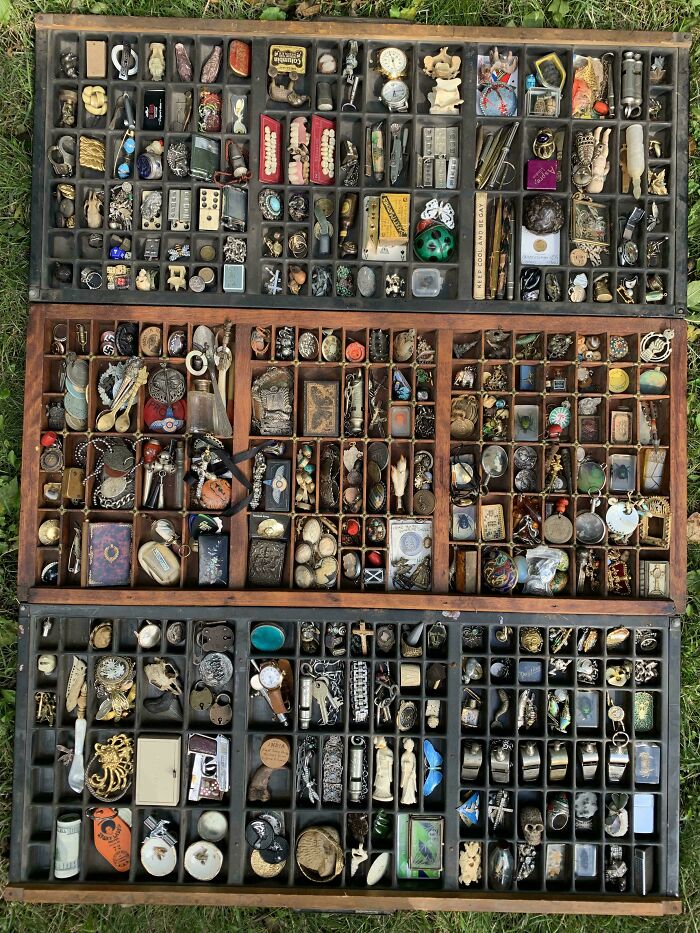 Wooden display case with various small collectibles neatly arranged in compartments, showcasing satisfying knolled order.